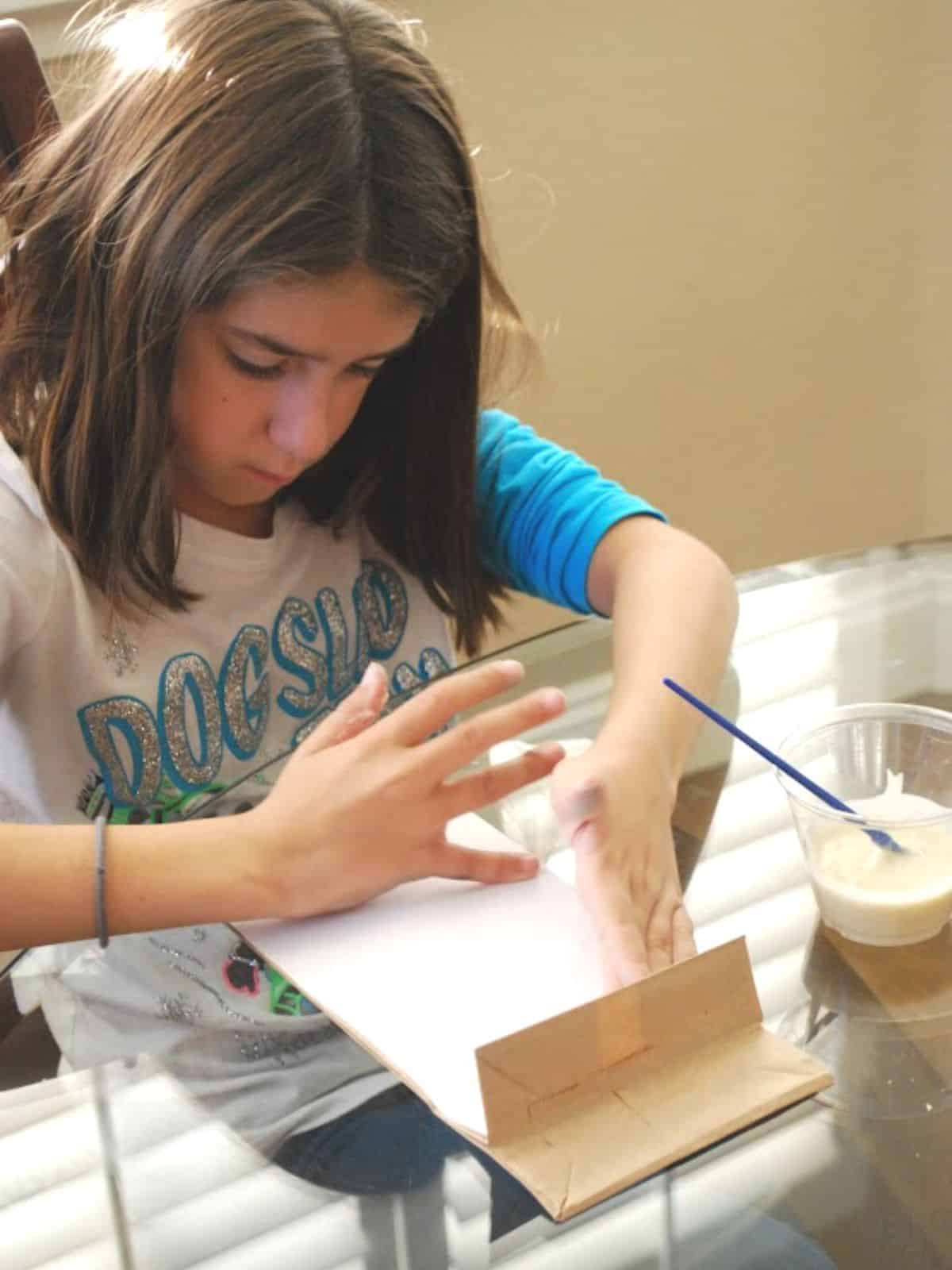 child making a paper bag craft.