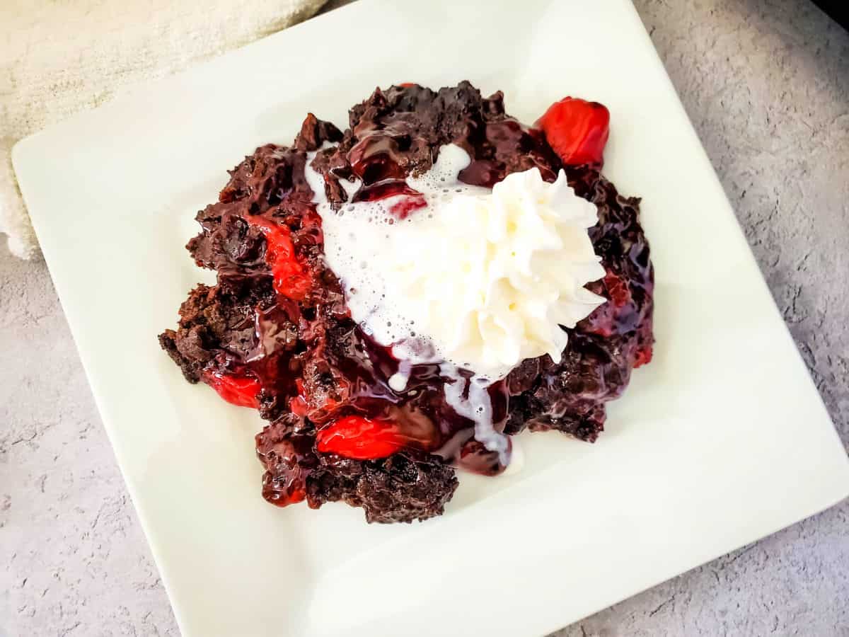 chocolate cherry dump cake on a white plate.