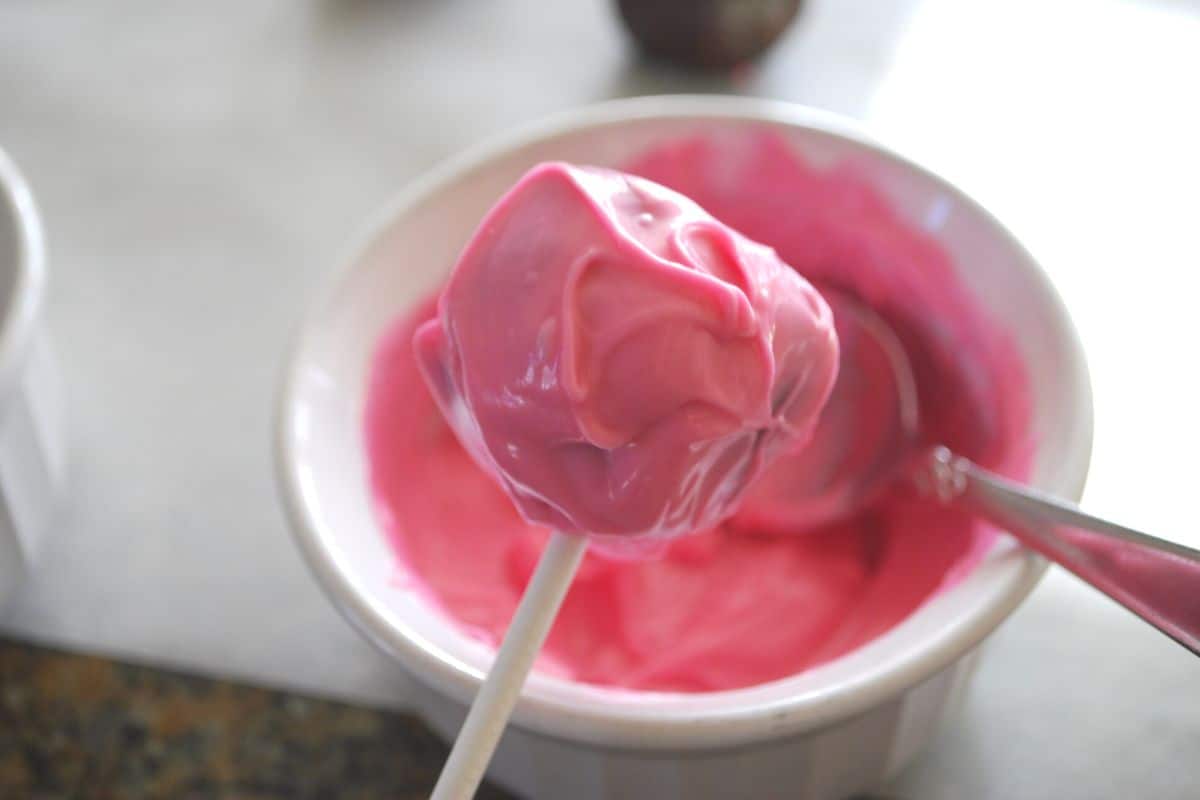 dipping cake pop in melted chocolate