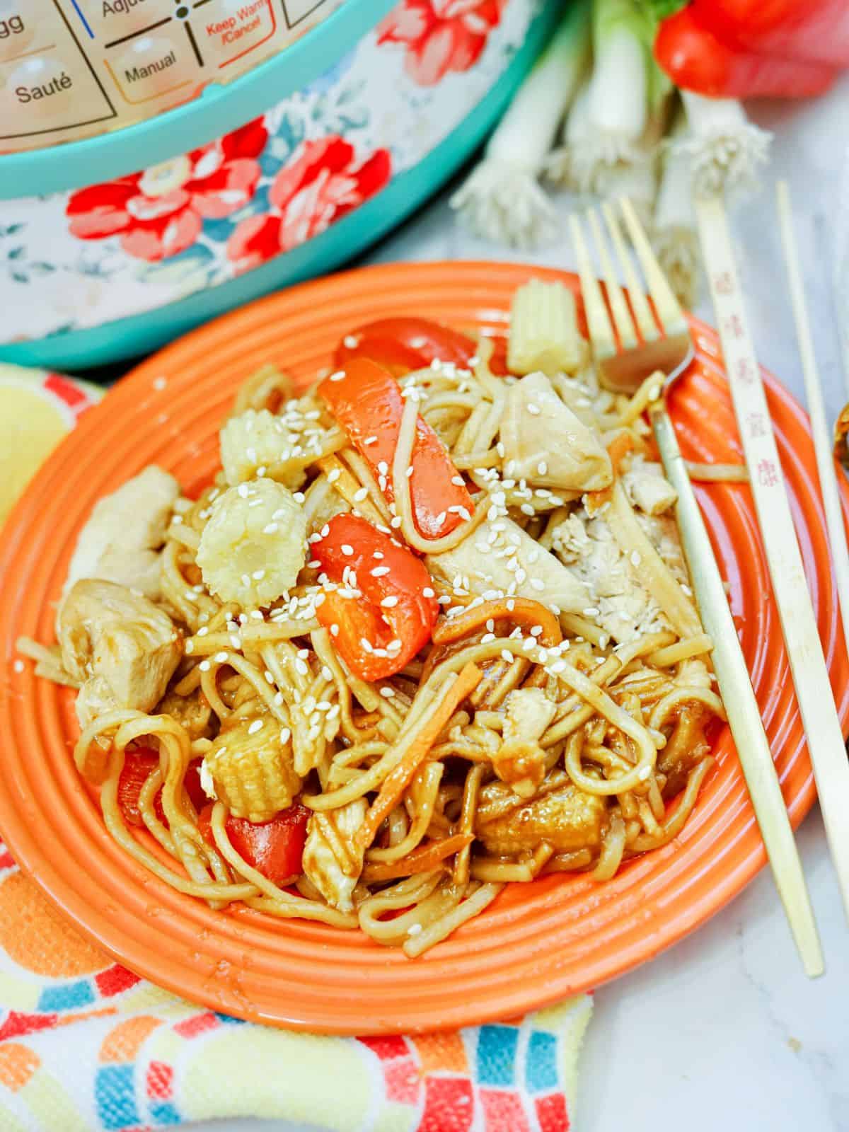 chicken lo mein on orange plate