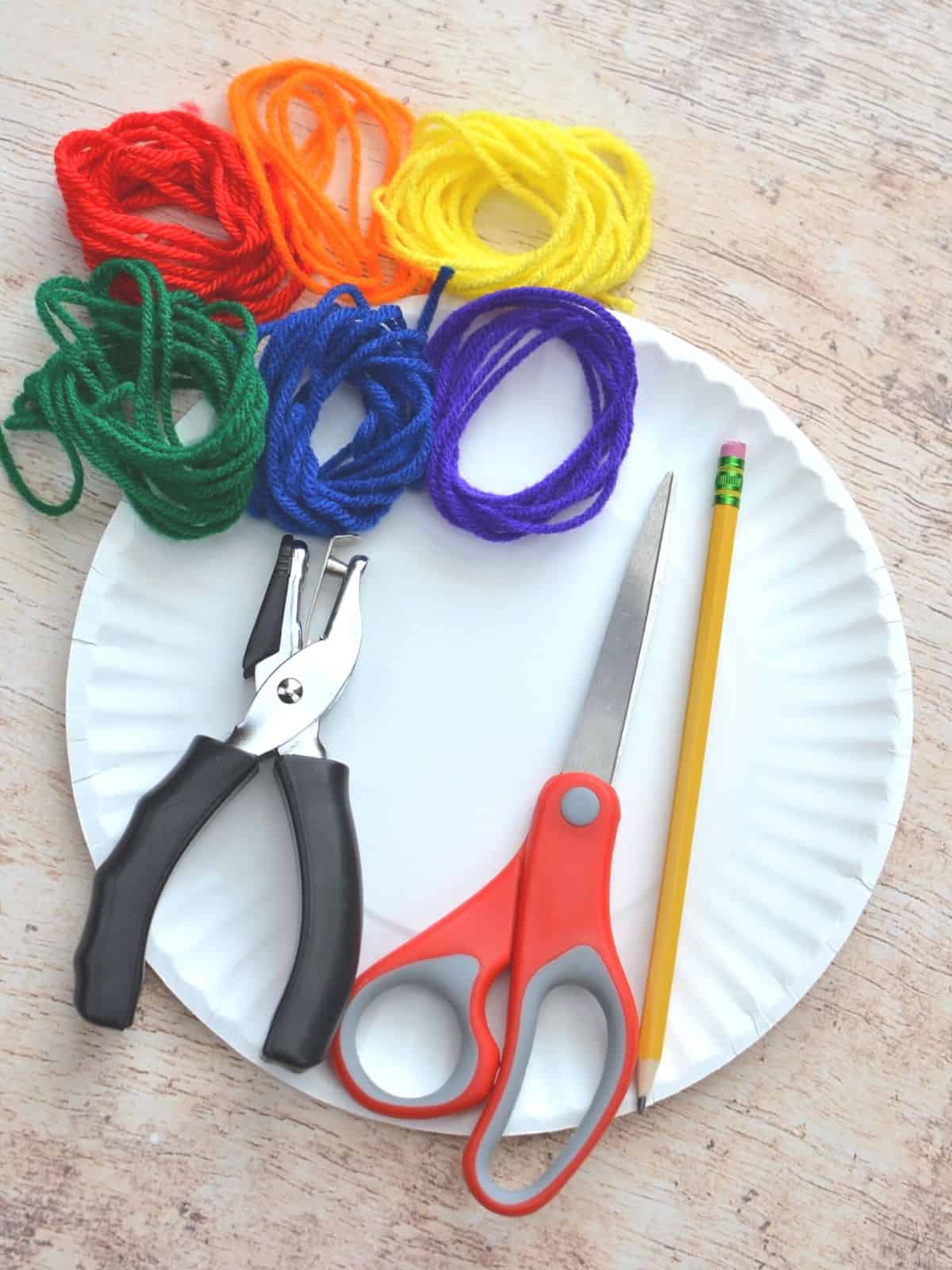 paper plate, hole punch, scissors, pencil, yarn