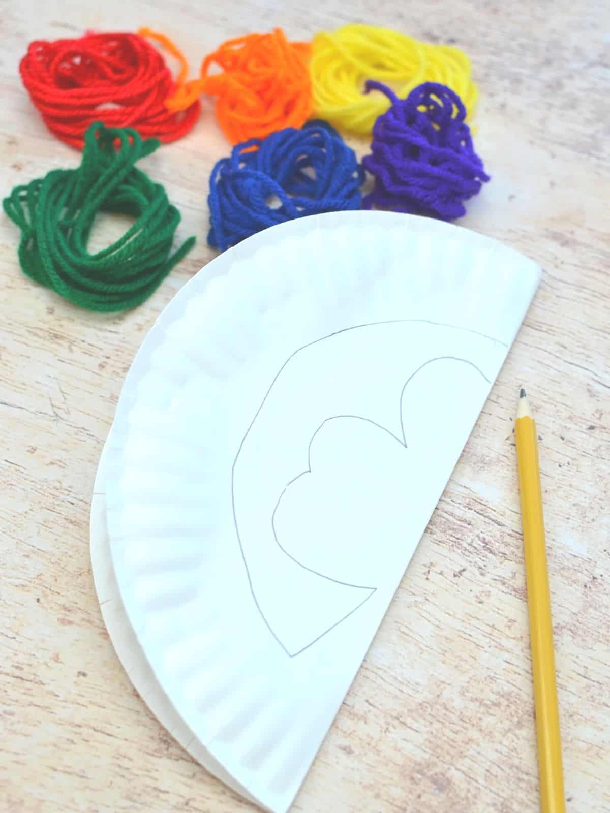 paper plate with rainbow colored yarn