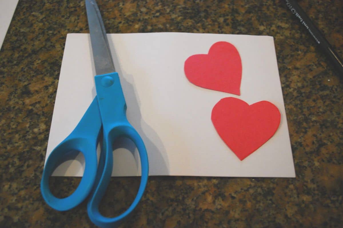 scissor white paper and red paper hearts