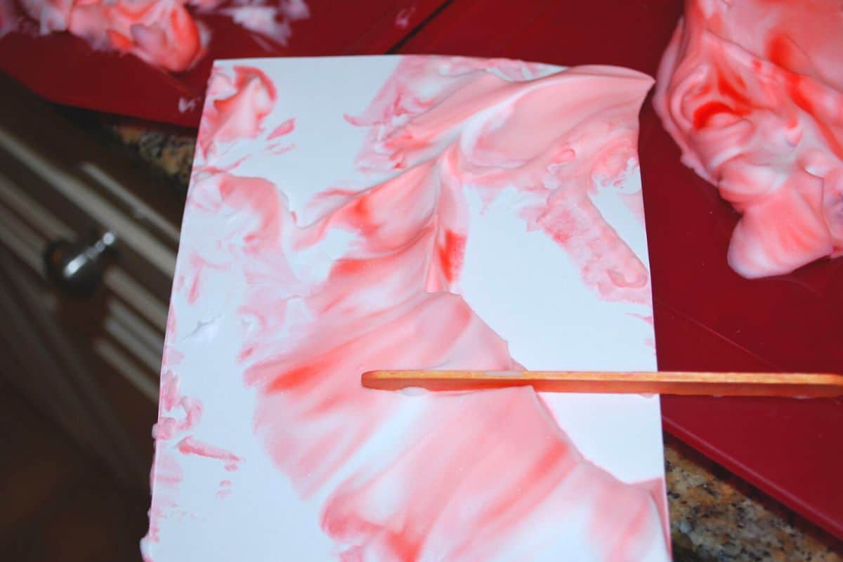 shaving cream scraping shaving cream off paper with popsicle stick