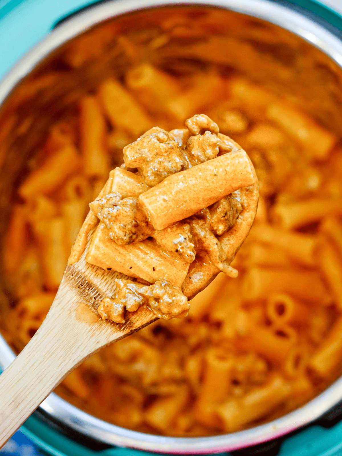 instant pot with pasta and spoon with rigatoni and sausage