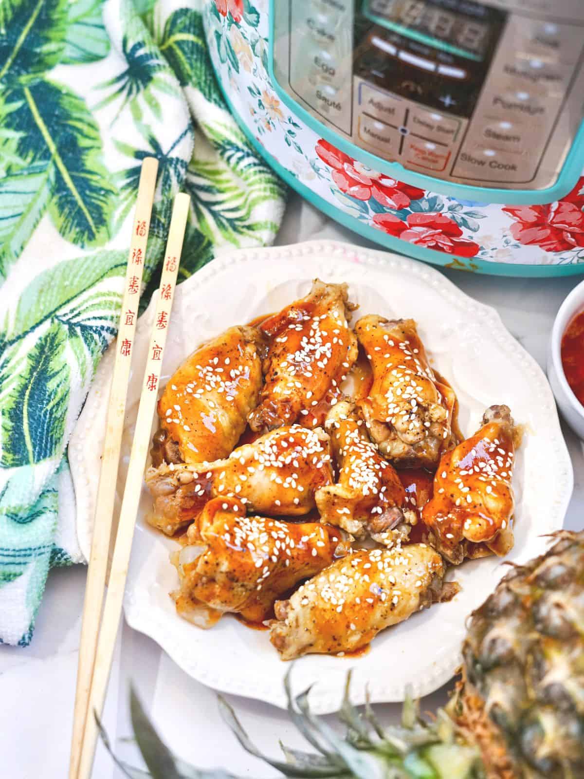 instant pot teriyaki wings on plate with chopsticks.