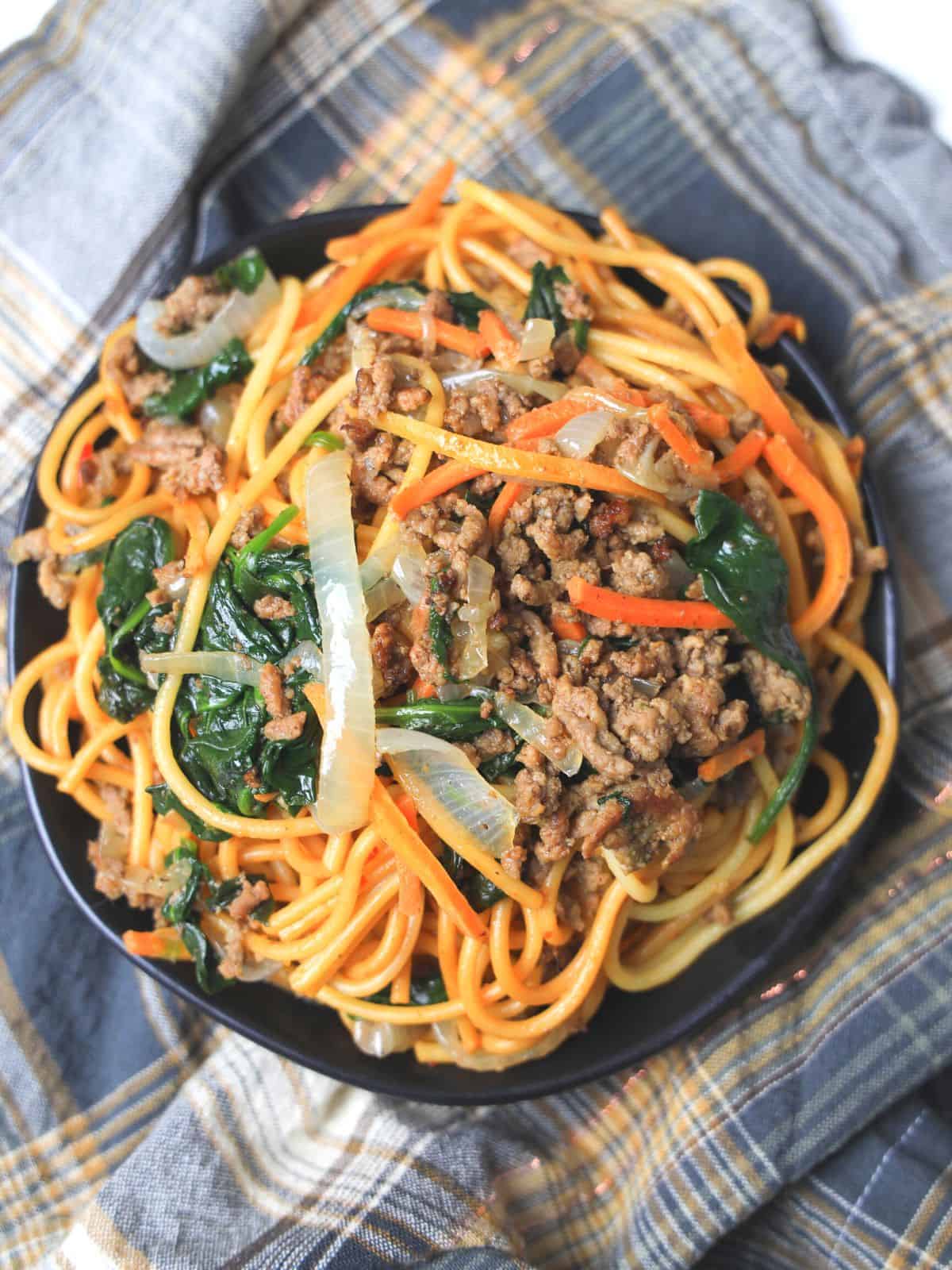 Chinese spaghetti on plate with with plaid towel