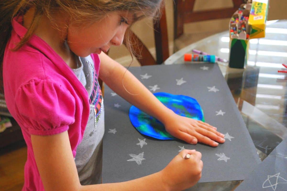 child making earth and space scene.
