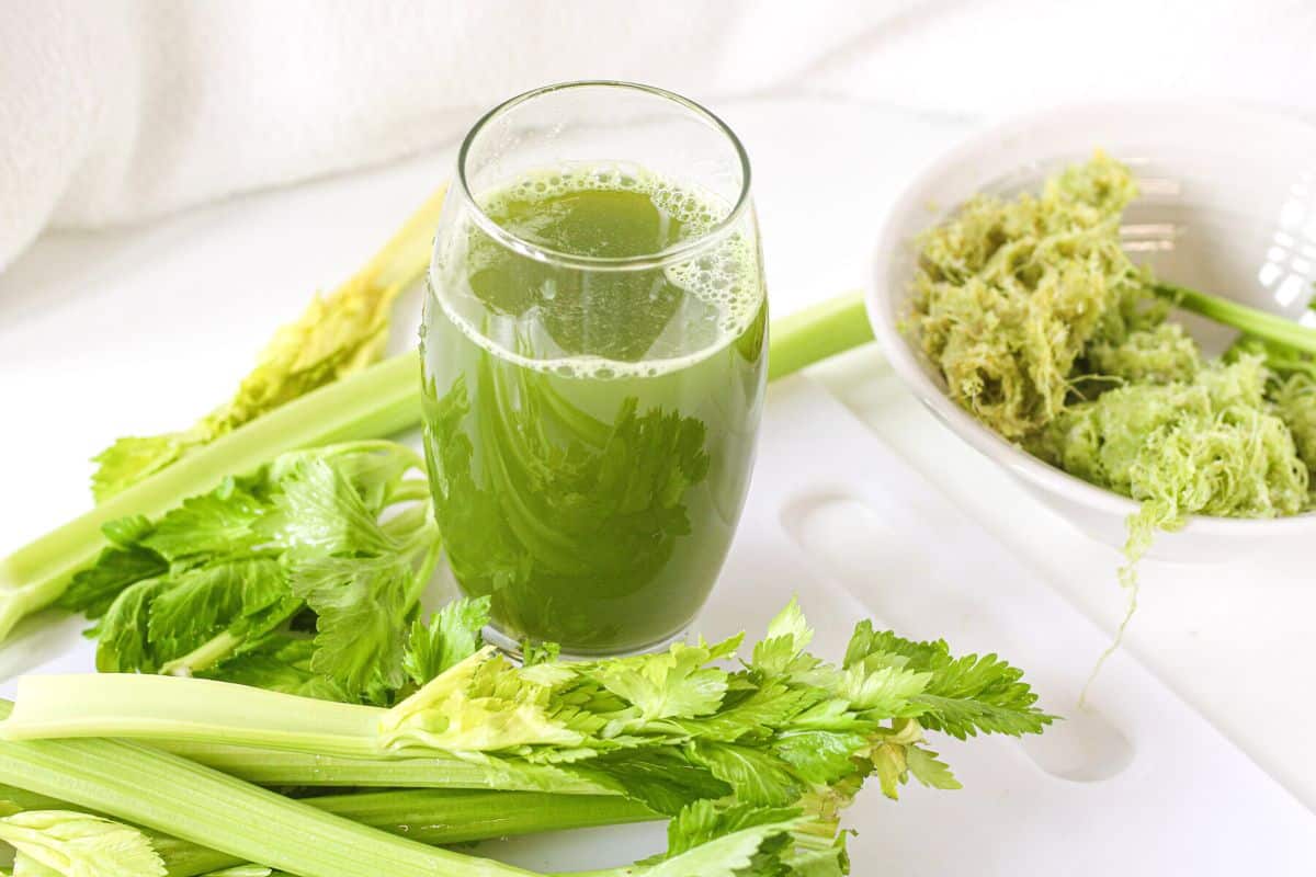 glass of celery juice with pulp on side