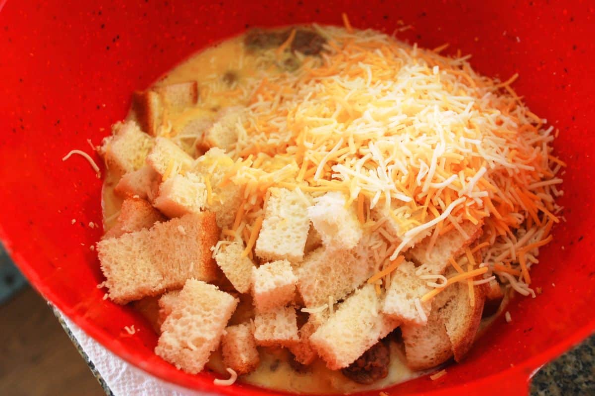 bread, egg, sausage and cheese in bowl.