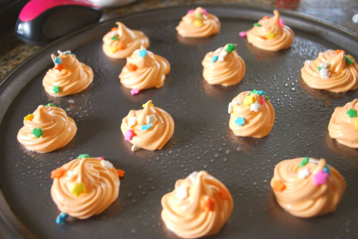 orange meringues on pan.