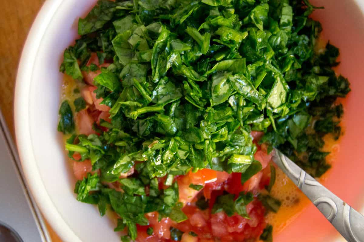 spinach and tomatoes in bowl with eggs