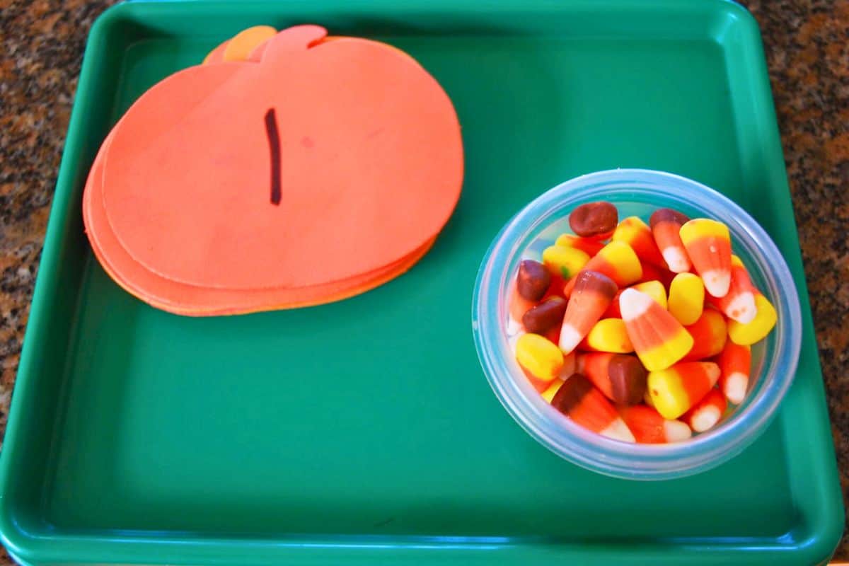 candy corn and foam pumpkins on tray