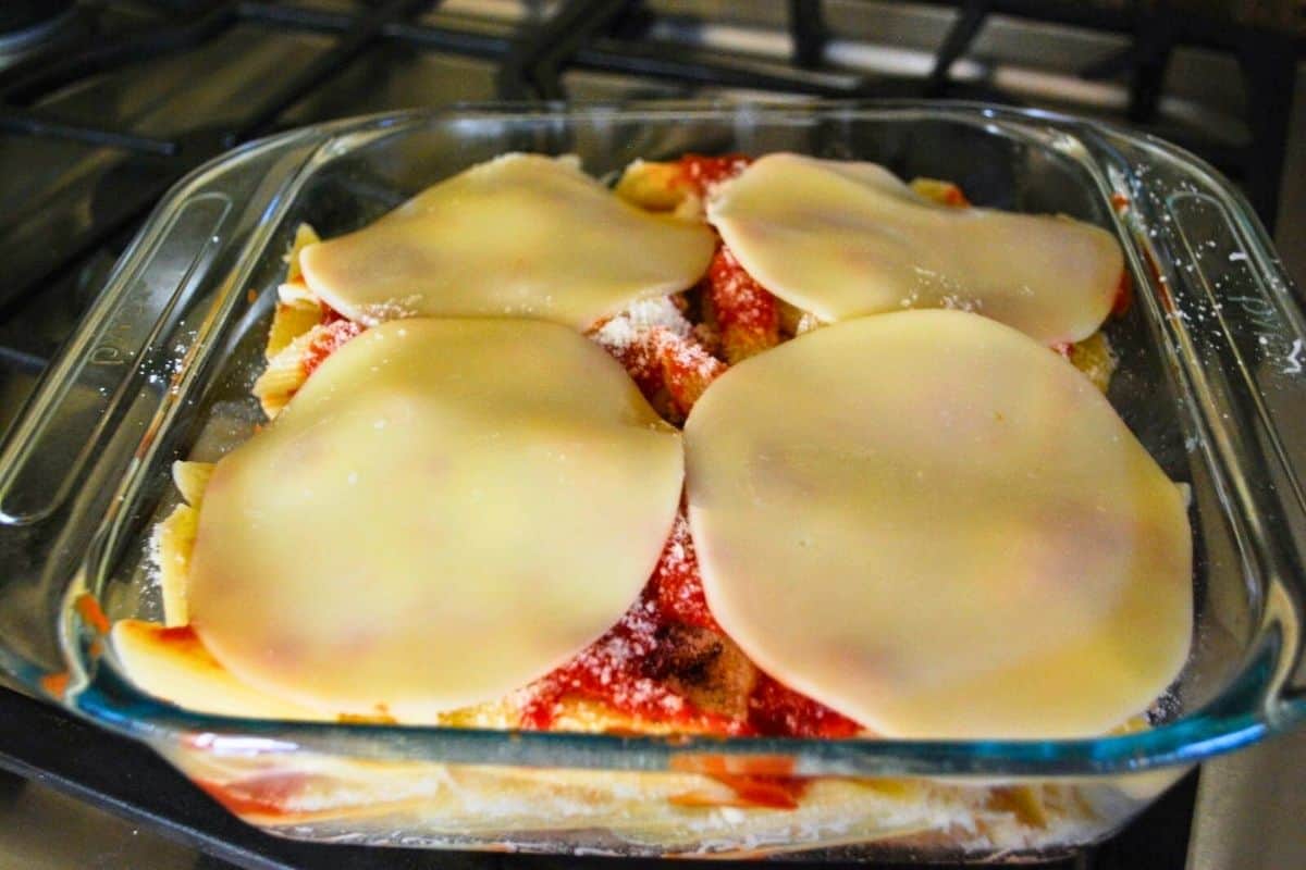 chicken and pasta casserole topped with sliced provelone.