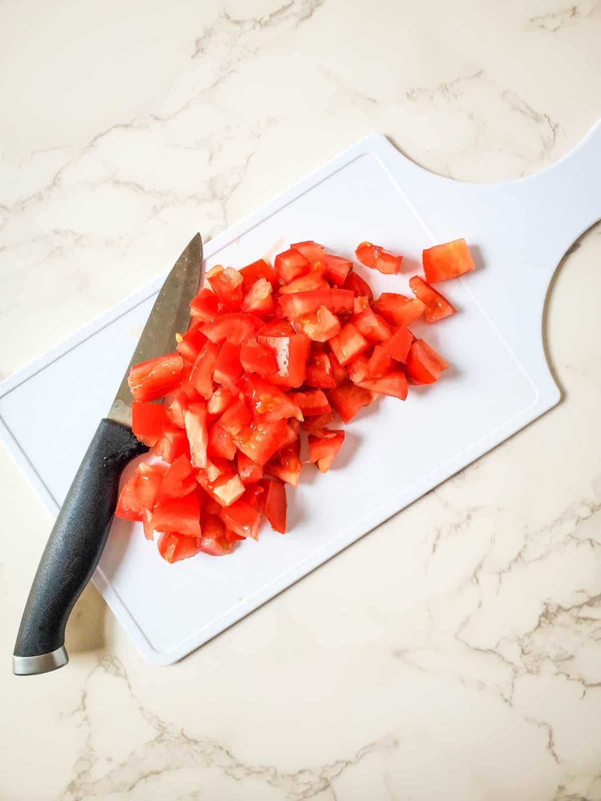 chopped tomato on cutting board.