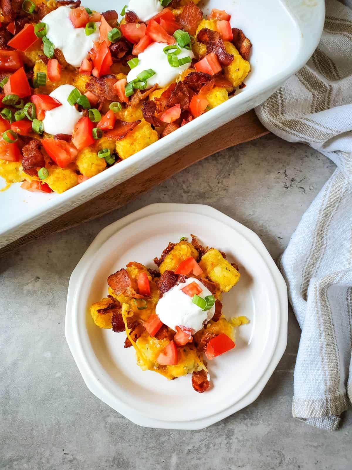 loaded tater tot casserole on white plate.