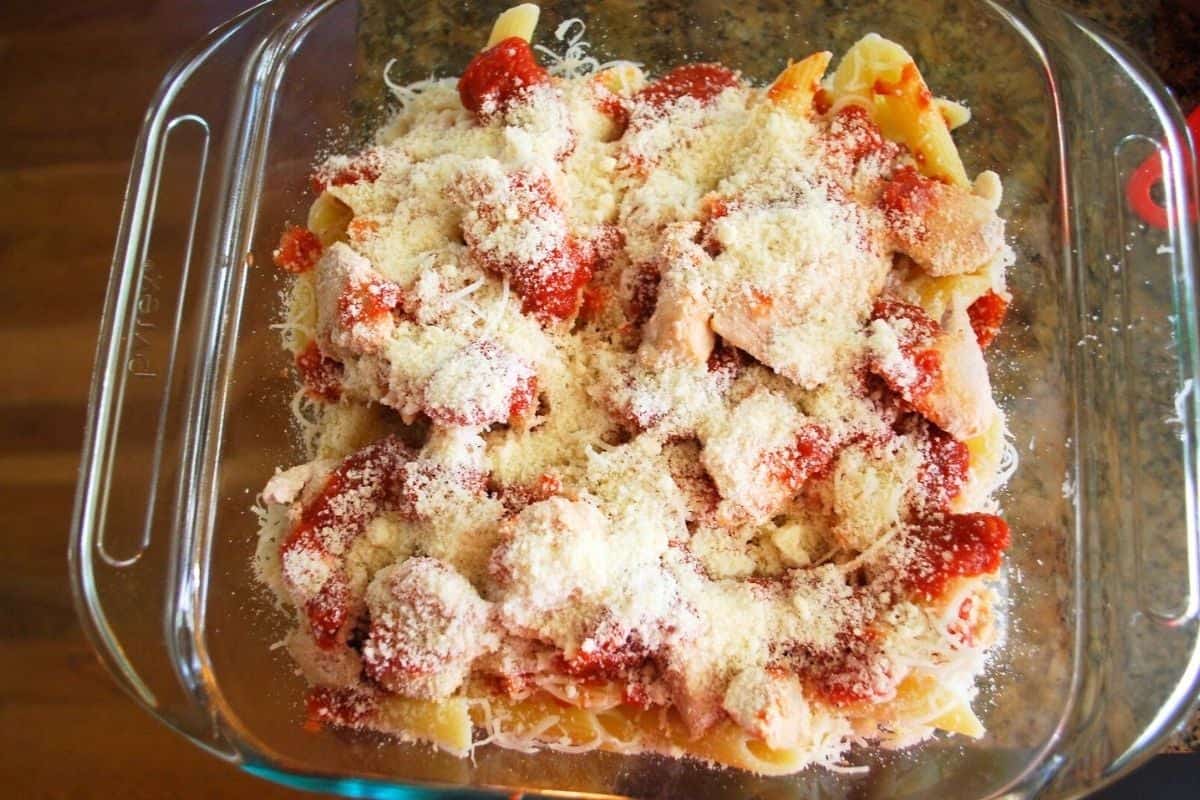 pasta chicken sauce and shredded mozzarella in baking dish.