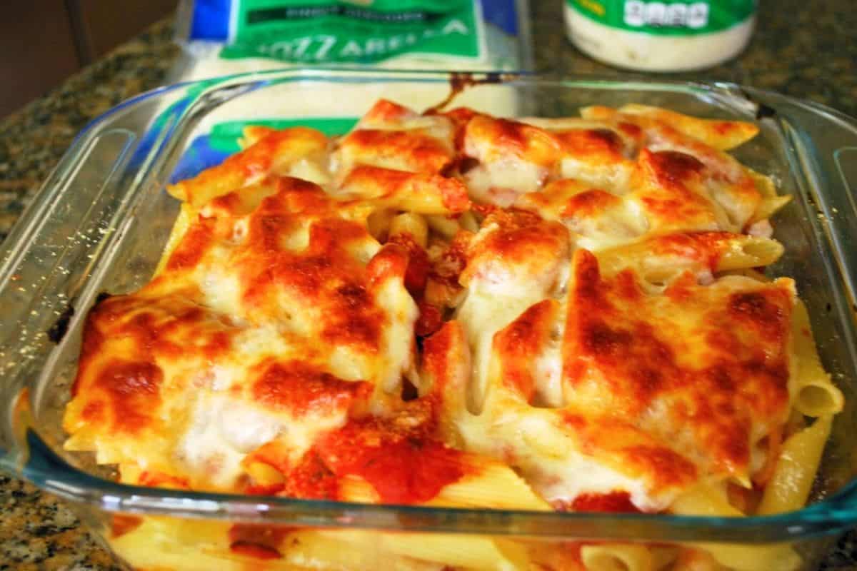 pasta in a baking dish with sauce and mozzarella.