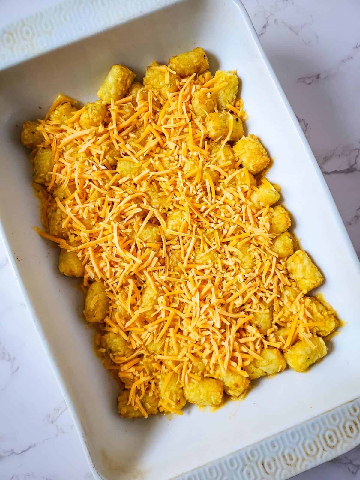 tatertot casserole with cheese in pan.