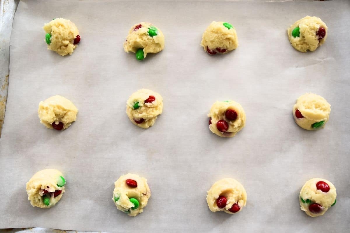cookie dough with M&MS on cookie sheet.