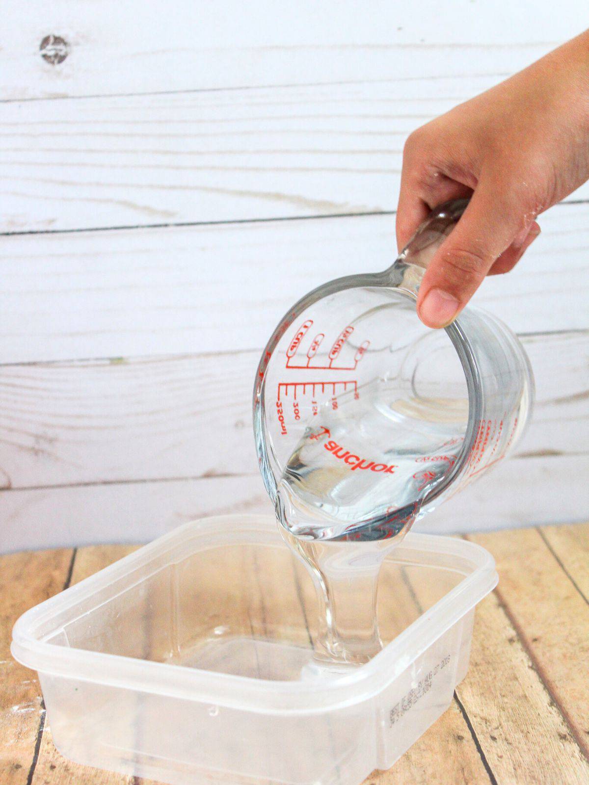 pouring glue into a bowl to make slime.