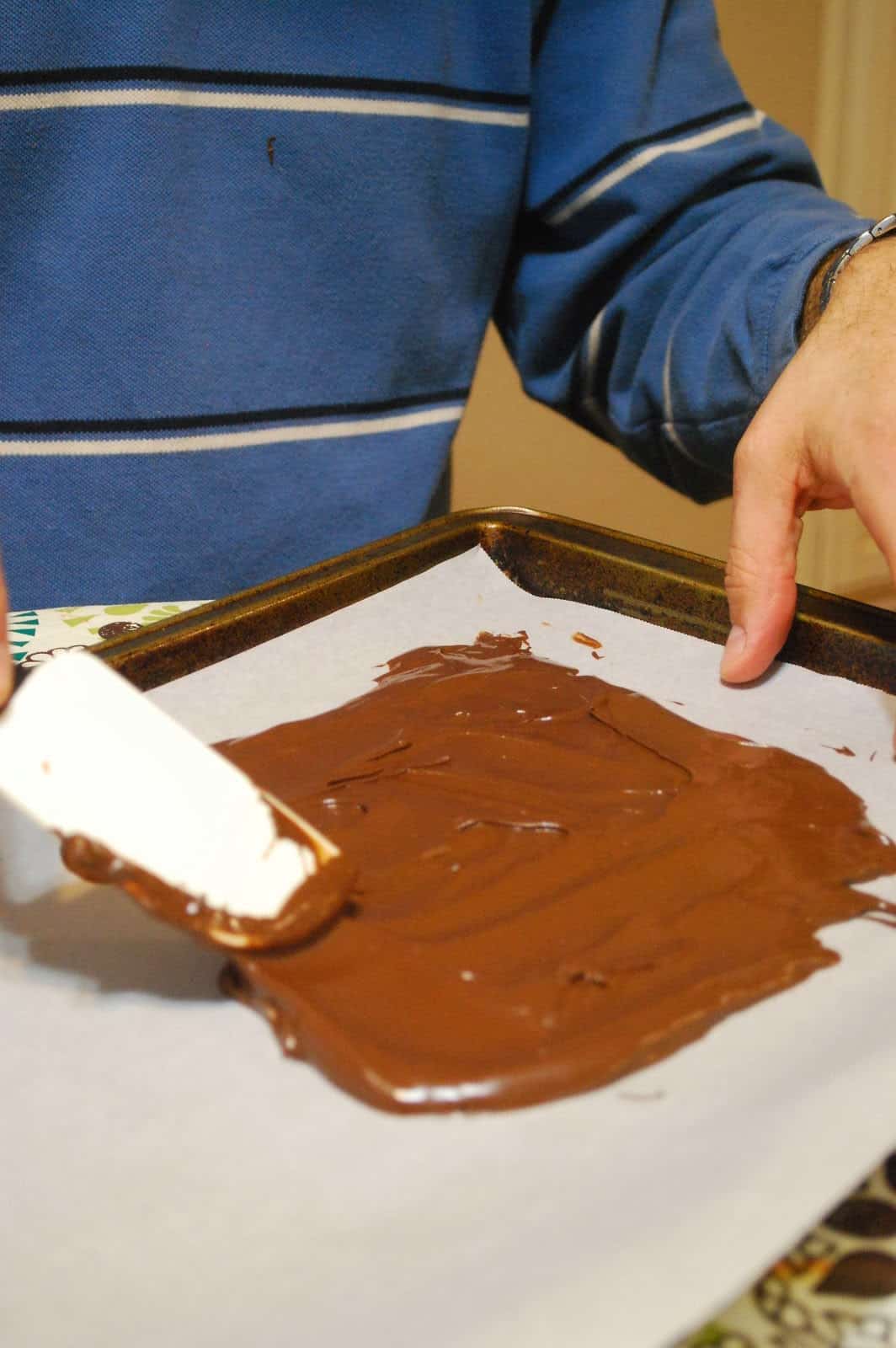 spreading chocolate in a pan.