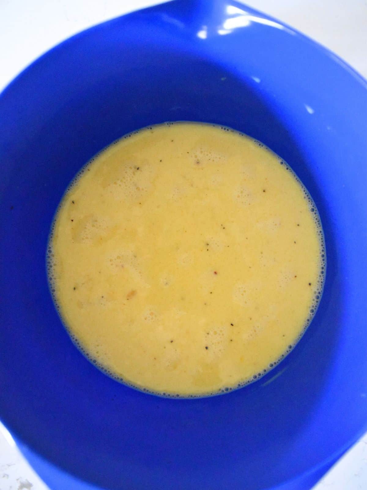 whisked eggs and milk in bowl.