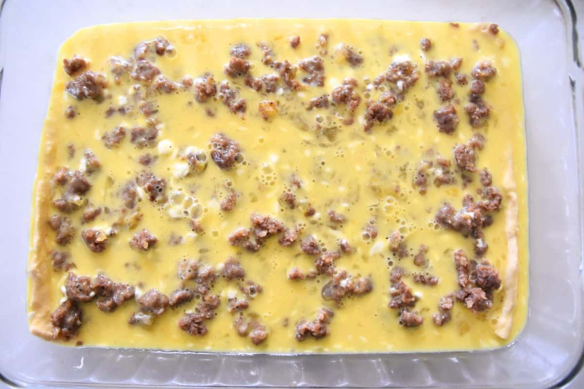 raw eggs and sausage in casserole dish