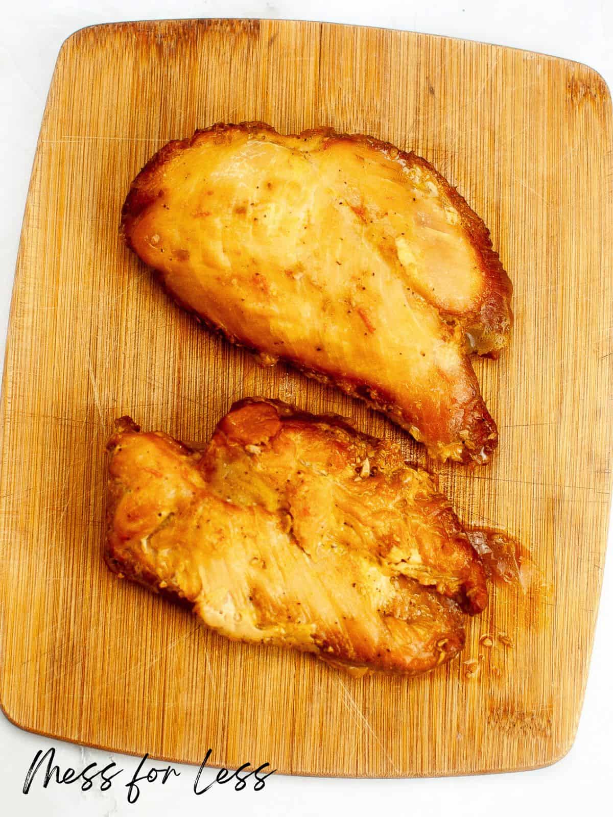 Cooked chicken breasts on cutting board