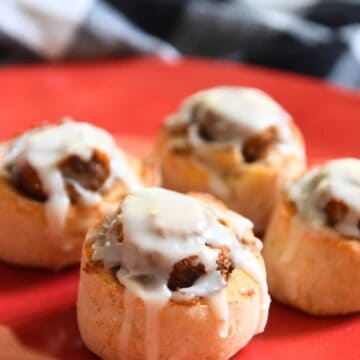 4 small cinnamon rolls on red plate