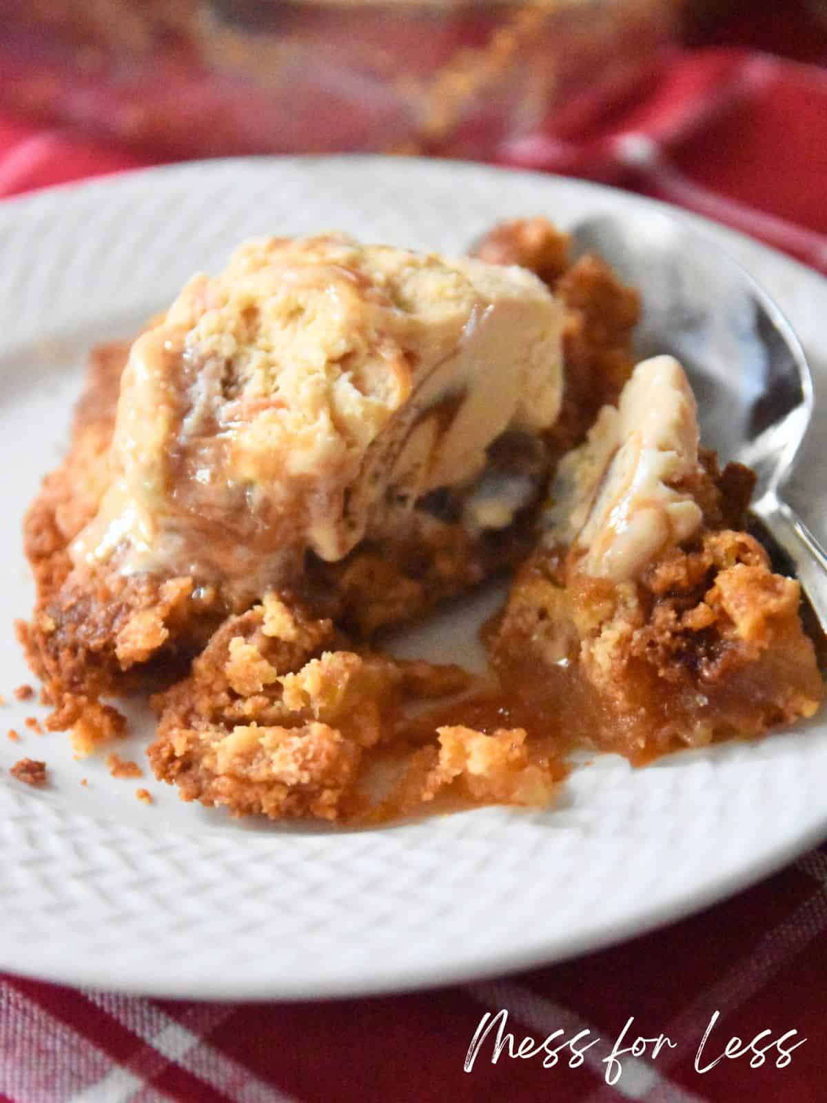 Apple dump cake on plate with ice cream and spoon