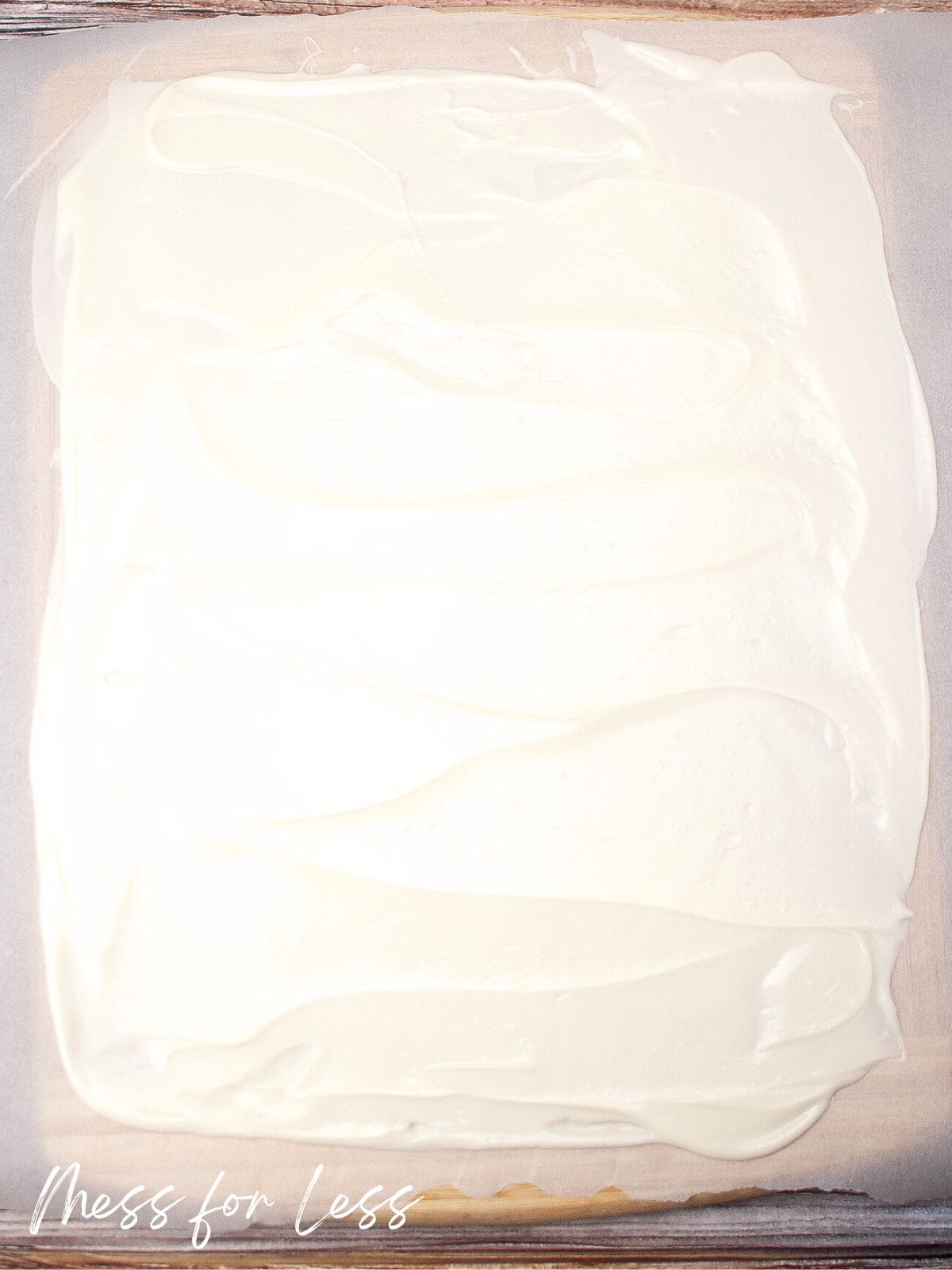 Melted white chocolate spread on parchment paper