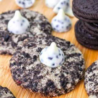 cookie and cream cookies with hersehy's kiss on top on cutting board