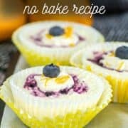 Lemon blueberry mini cheesecake cups topped with fresh blueberries and lemon zest in bright yellow wrappers, text overlay included.