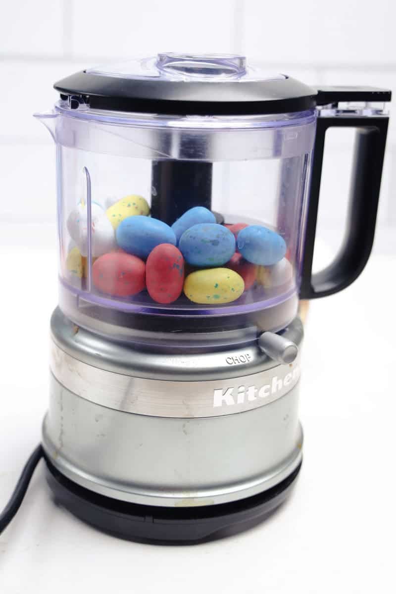 A food processor on the kitchen counter is filled with colorful, speckled eggs, reminiscent of a delightful Robins Egg Easter Dip.