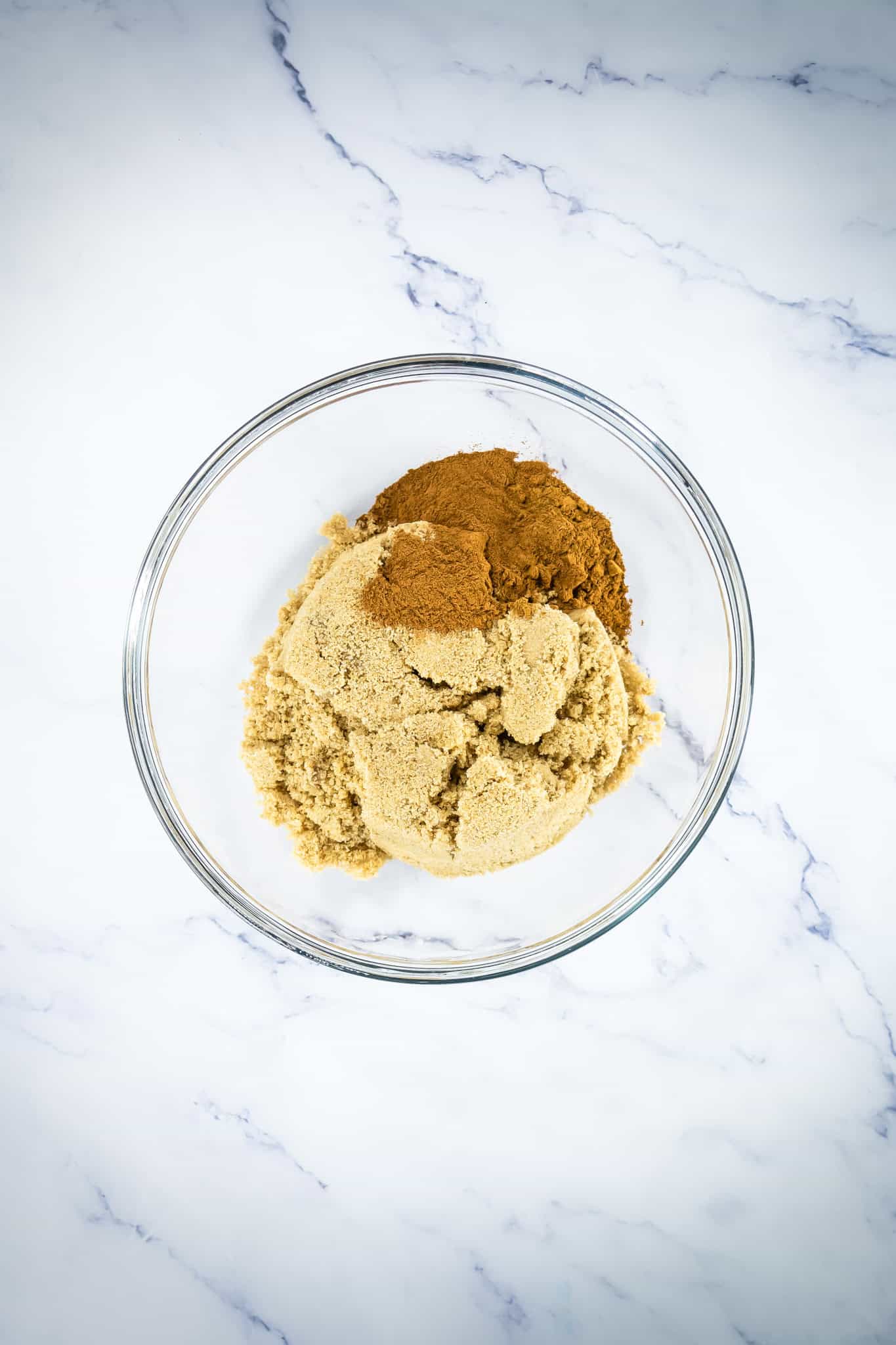 Ground cinnamon and brown sugar in a glass bowl