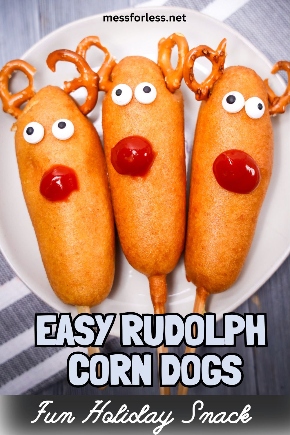 Three Rudolph Corn Dogs decorated as Rudolph with pretzel antlers, candy eyes, and ketchup noses are served on a white plate—festive and fun for any holiday gathering.