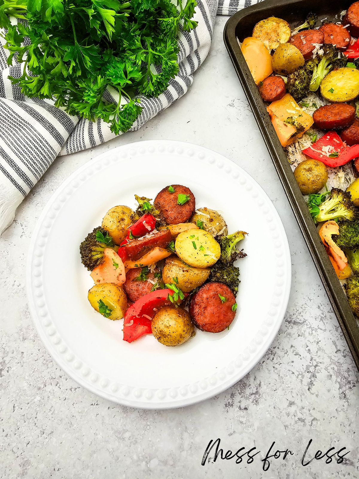 A white plate of roasted sausage, potatoes, broccoli, and peppers—delicious sheet pan veggies