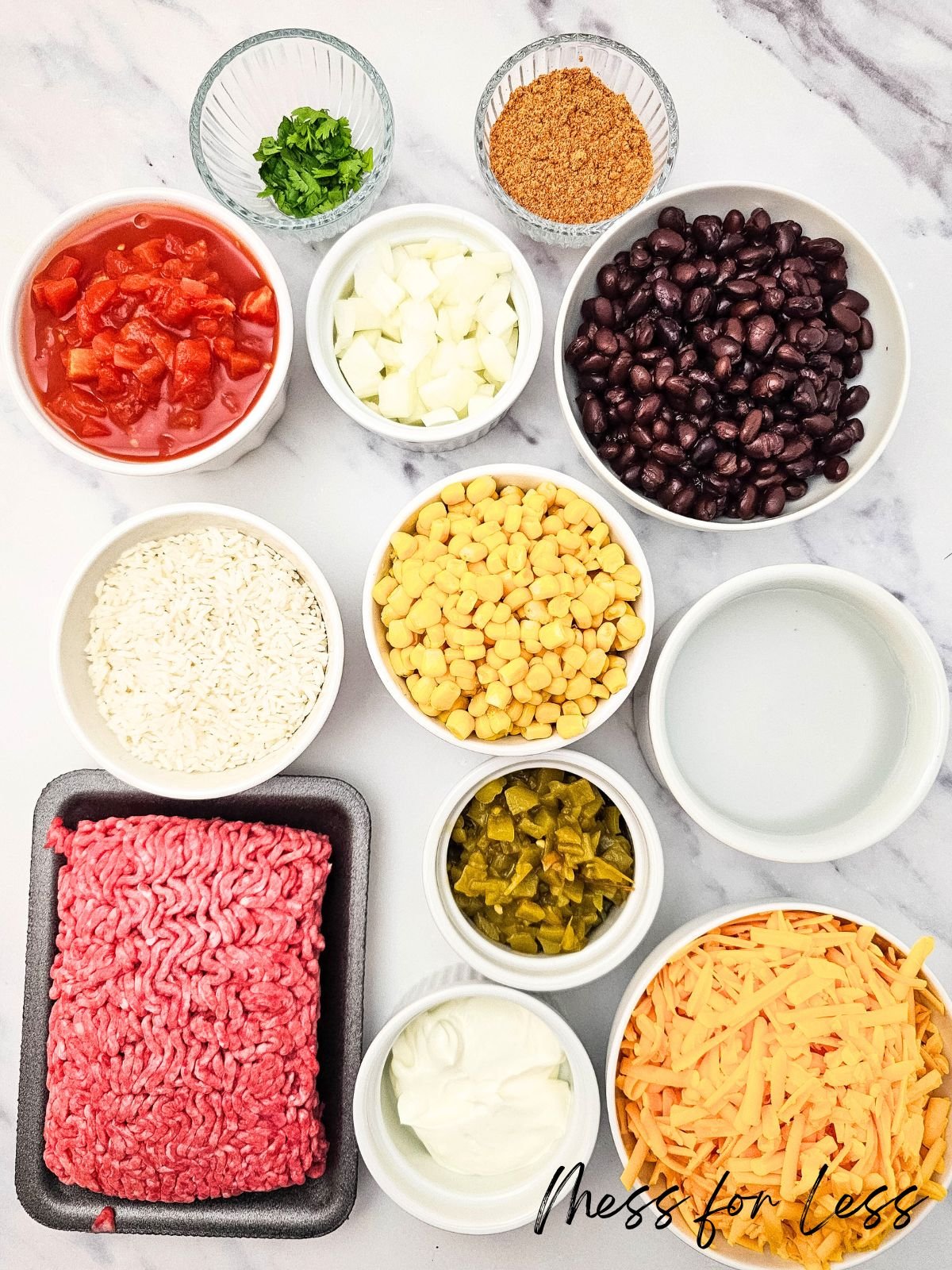 Taco Rice Casserole ingredients: ground beef, beans, tomatoes, corn, cheese, rice, onions, and flavorful seasonings.